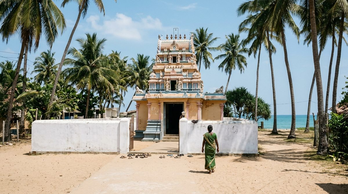 Petit temple hindou à tour colorée entre les cocotiers près de la baie de Passikudah, un chemin de sable clair mène à l’entrée